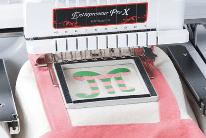 White and pink bag in clamp frame on embroidery machine